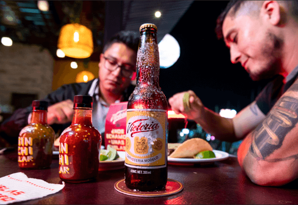 Disfruta de cada bocado de deliciosos tacos mientras acompañas tu experiencia culinaria con el refrescante sabor de Victoria.